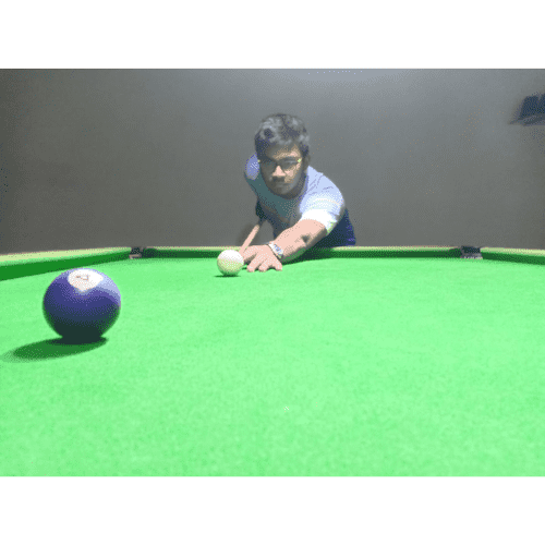 Akshet Patel lining up a shot on a pool table