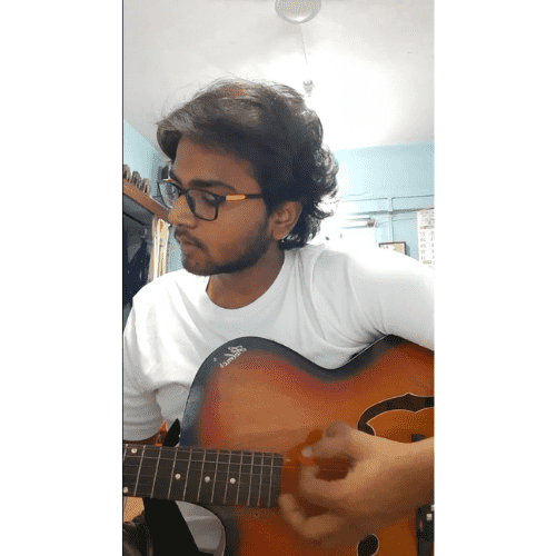Akshet Patel playing an acoustic guitar