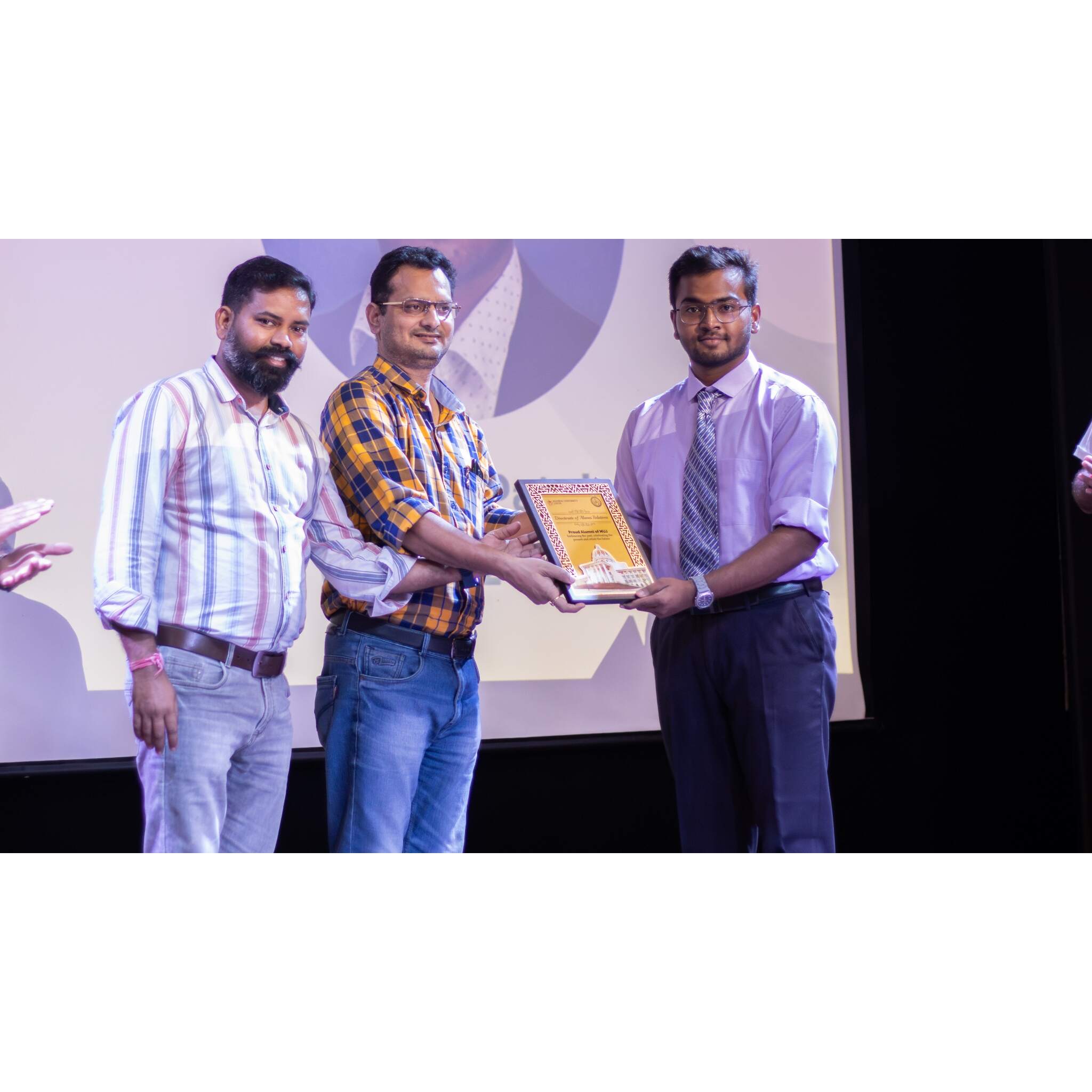 Akshet Patel receiving an award on stage